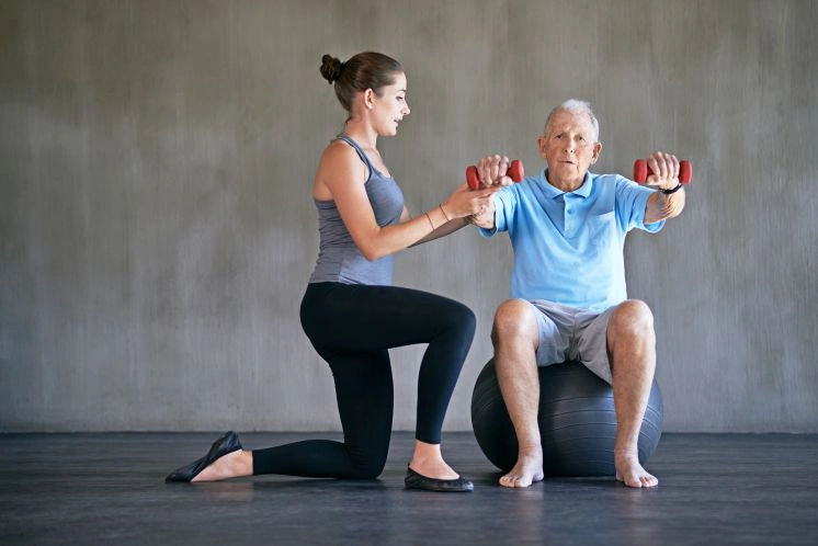 Senior man in sarcopenia resistance training with female therapist.