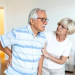 senior man back pain with wife support