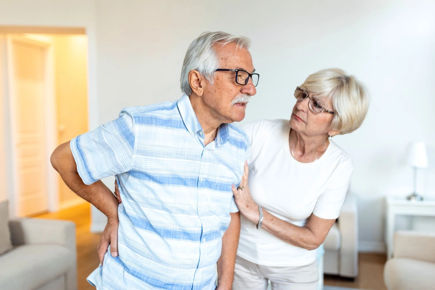 senior man back pain with wife support