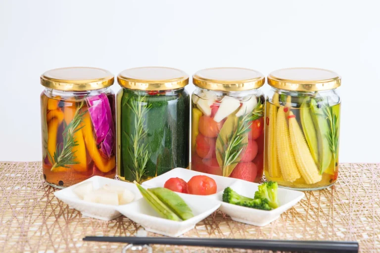 Jars of fermented fruits on a table for gut health, immunity, and digestion
